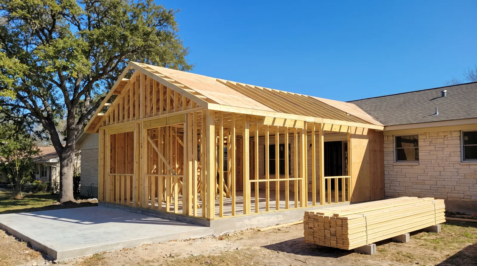 Room addition framed onto the back of a limestone ranch house
